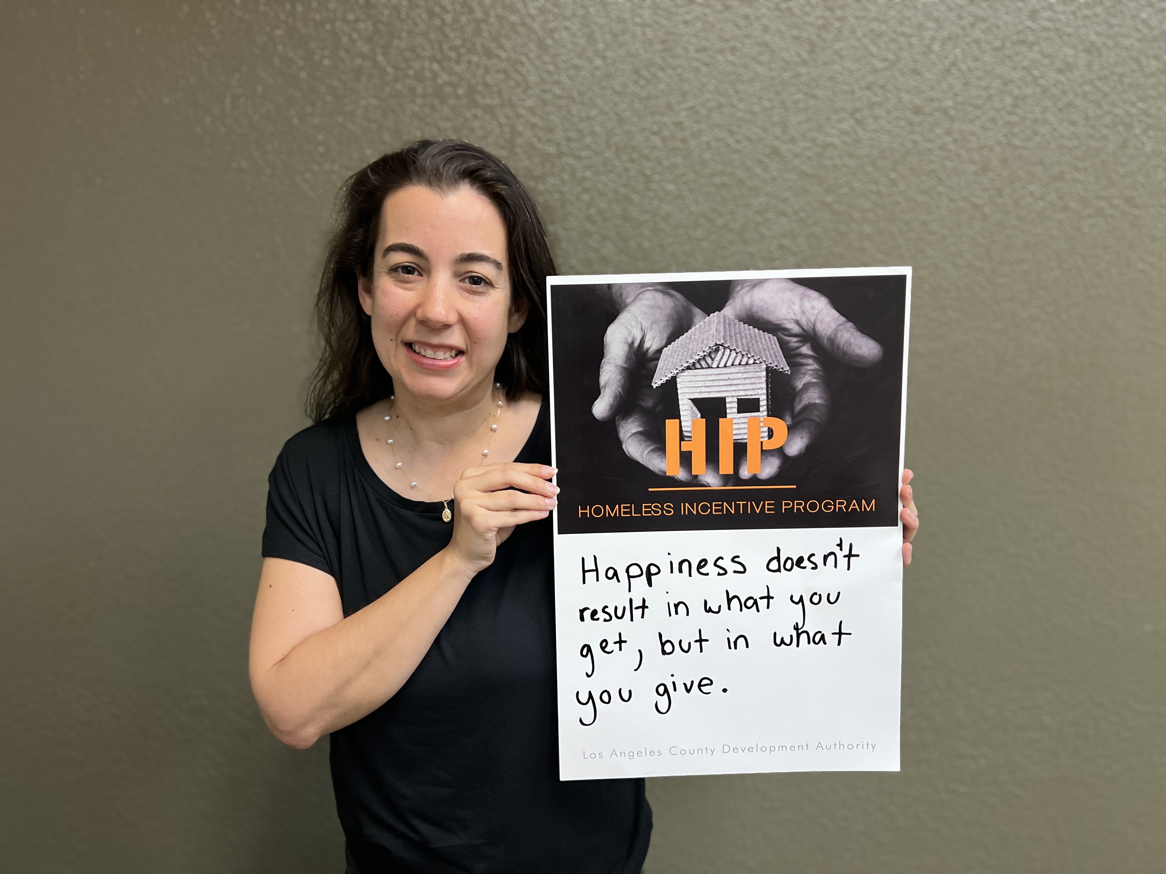 Woman holding Homeless Incentive Program poster.