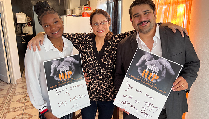 Group holding HIP Homeless Incentive Program signs.